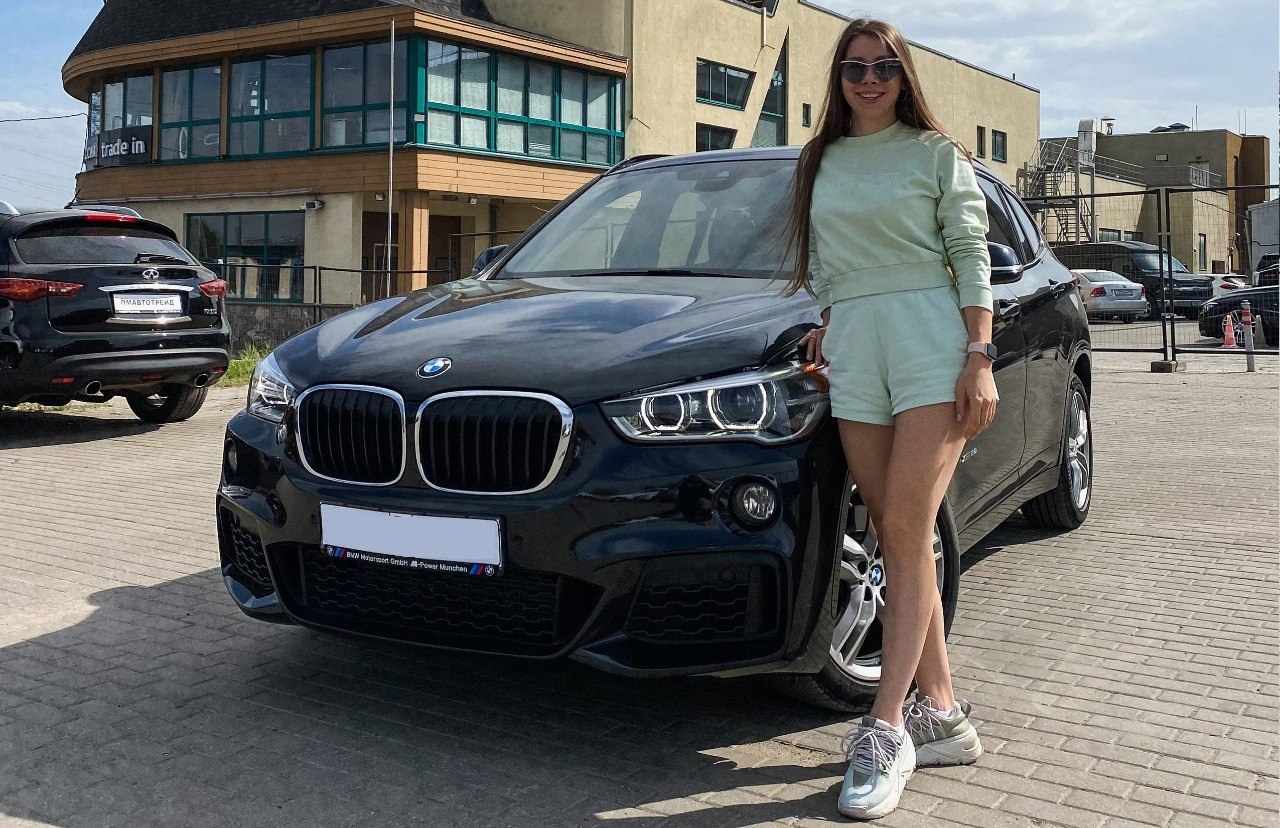 Довольная клиентка рядом со своим новым BMW X1